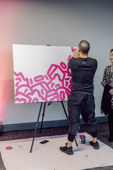 Artist Mike Han creates a pink line painting at last year’s event. 