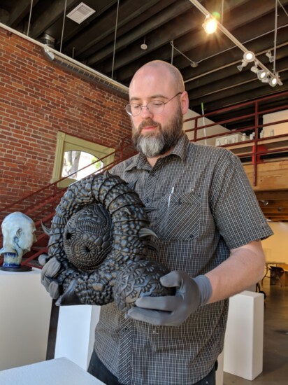An artist inspects his sculpture
