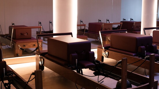 Strength-focused reformer Pilates with infrared heat for power and control.