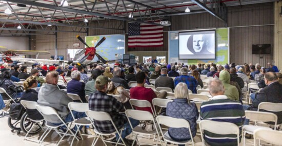 Guests listen to one of the Monthly Presentations on aviation history at Planes of Fame.