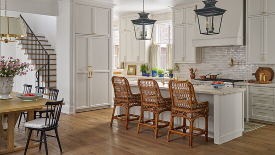 Black matte lanterns over the island mix with brass hardware and plumbing fixtures in this kitchen designed by Houston interior designer Katie Davis. 