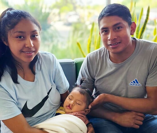 Young parents hold their little girl prior to her surgery.