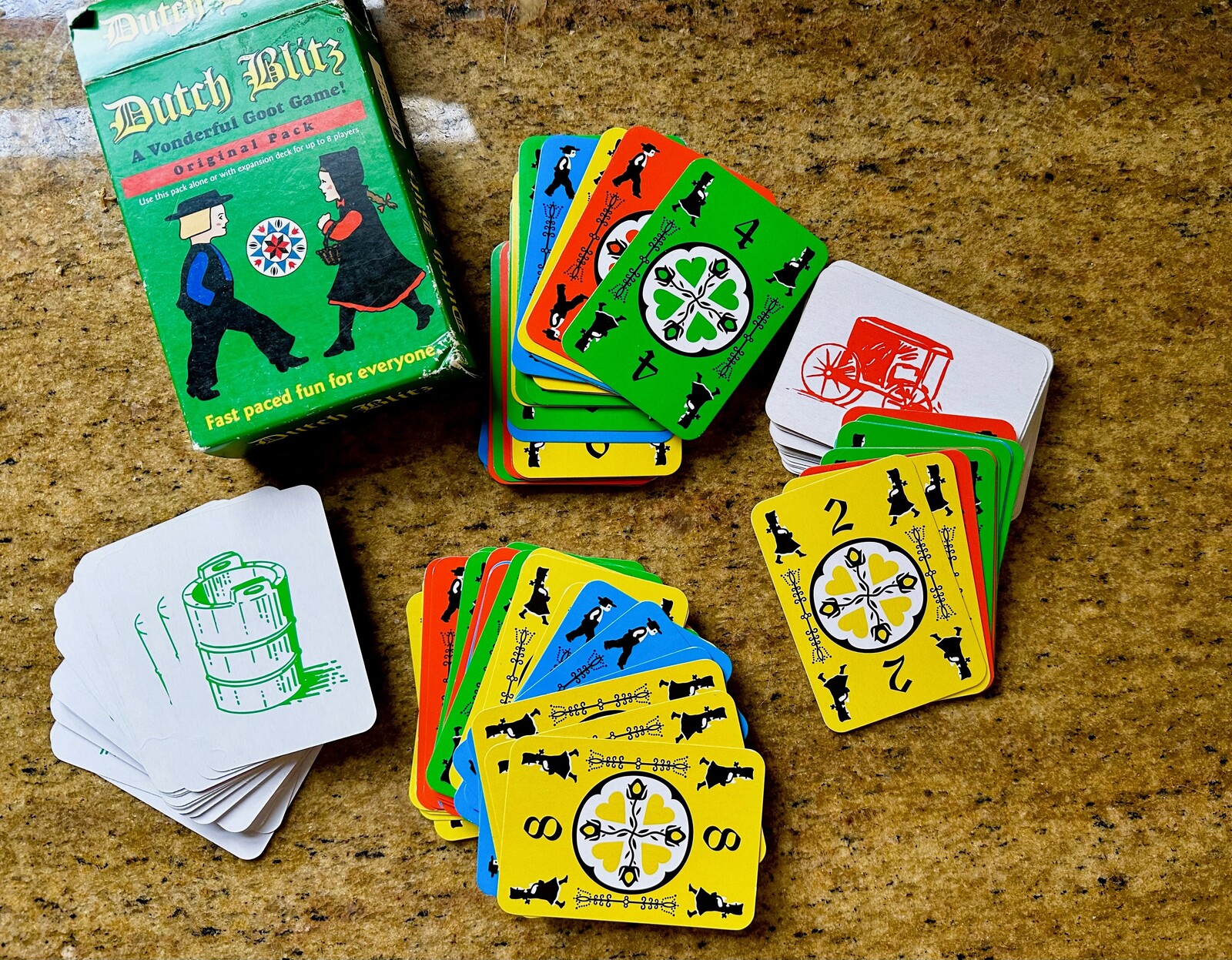 Dutch Blitz card game being played with colorful card piles