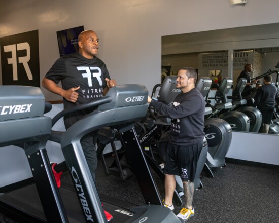 Lynn does his treadmill warmup as trainer Jason Santiago watches.