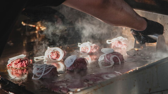 Burgers being smashed and cooked. Photo courtesy of Fuzzies Burgers.