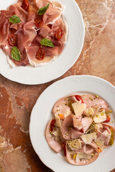 Appetizers include plates of mortadella and prosciutto di parma