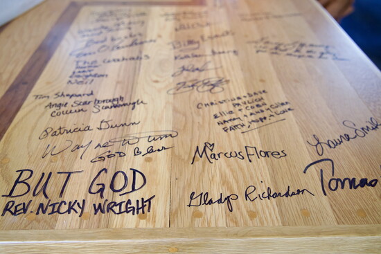 Volunteers are urged to sign this table featuring a cross made by Mike Scarborough. 