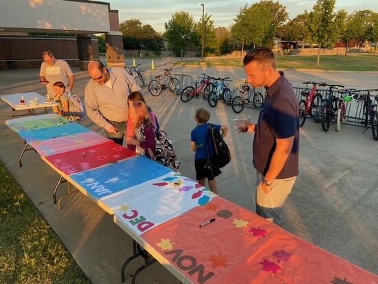 Dads gather at Bridlewood Elementary's Donuts with DOGS event to talk about volunteering. 