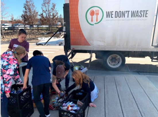 Students from Lone Tree Elementary helping load donated food for We Don't Waste.