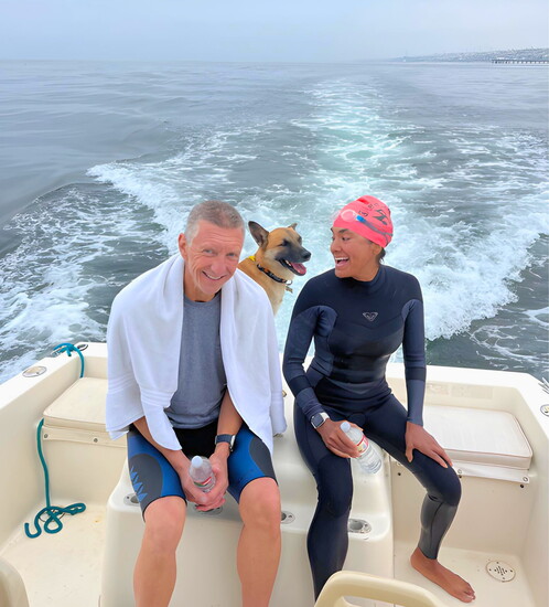Vera and her swim buddy Dave Keller, with her dog Rufus, relax after achieving her 2.45-mile open water swim goal.