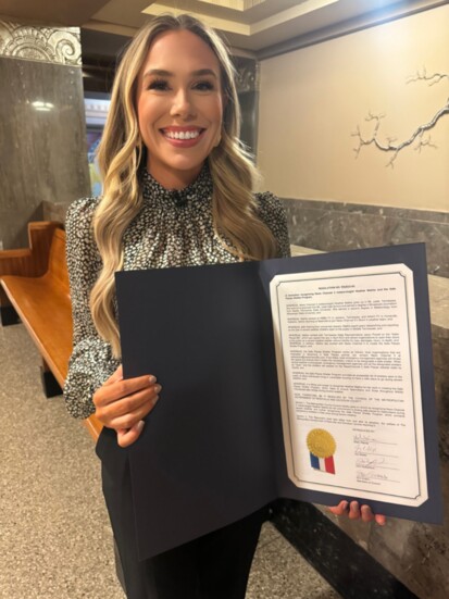 Heather Mathis holding the Resolution passed by Metro Council honoring her work on Safe Places.