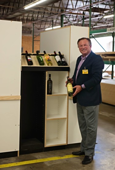 Jeff Reasor, CEO of Reasor' s Grocery chain stands in front of a partially completed wine set up that will be in his stores on October 1.