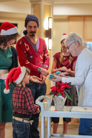 A heartfelt moment fostering community as young and old come together to share joy, connection, and the spirit of giving.