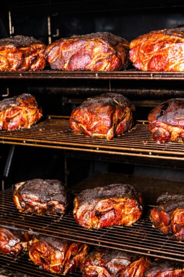 A bevy of smoked pork shoulders awaiting prep for menu items at Wunsche Bros. 