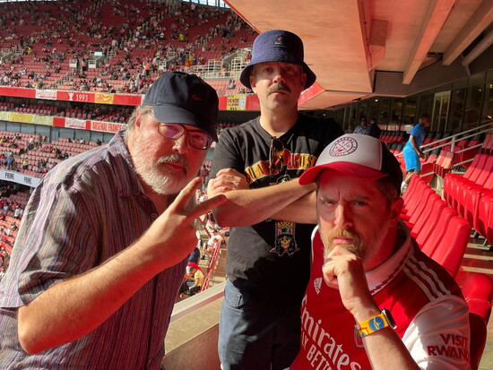 Hunt with "Ted Lasso" co‑creators Joe Kelly and Jason Sudeikis at an Arsenal match at Emirates Stadium in August 2022.