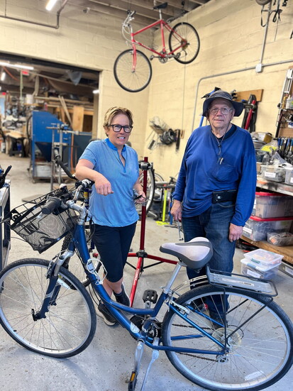 Dawn Przychodzien and Matt Glenn, co-leaders of the Seacoast Pedal It Forward group, stand with a repaired bicycle that will be donated to those in need. 