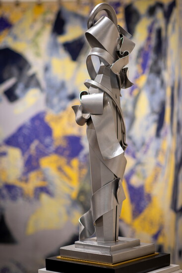An Albert Paley sculpture with one of his rugs behind it