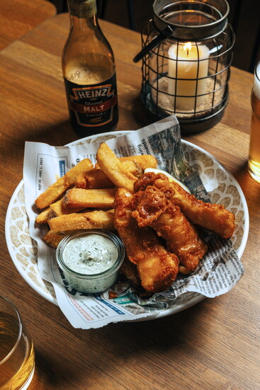 Crispy, golden-battered fish pairs with hand-cut chips and a tangy dill tartar for a classic pub favorite. (Photo credit Ballyhoo Hospitality)