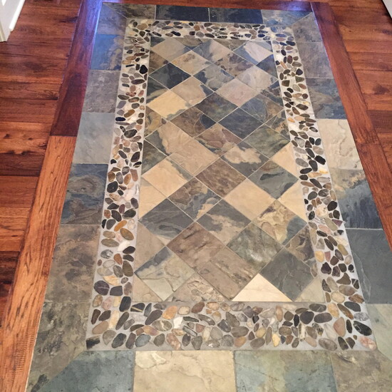 The Remodeling Showroom created a statement entrance way floor mixing wood, tile, and stone.