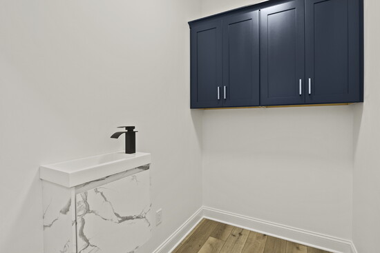 Designed for pets, with custom cabinetry, a dedicated pet wash sink, and a nook for a cozy bed. | Design by Greater Living Architecture; Photos by Real 3D Media
