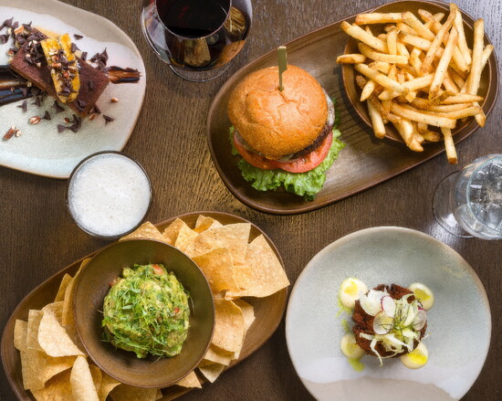 A Conroux table brings together shareable favorites, including guacamole, the grass-fed cheeseburger, crisp fries and fresh seasonal plates.