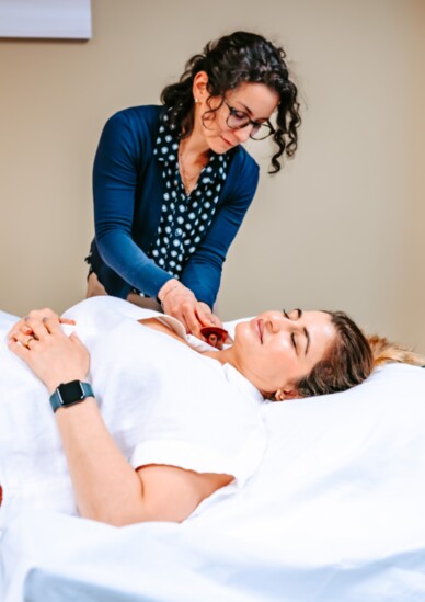 Jacqueline Fusari, standing, demonstrates a treatment in the new Wholeness Acupuncture Center. 