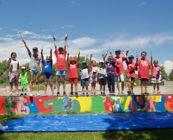 Volunteers from the Windsor community come together to help paint a mural at the Eastman Park Skate Park.