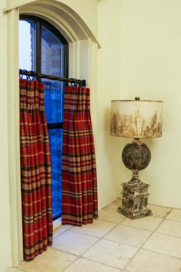 To compliment the warm tones of the travertine counters, the designers chose a rich wool plaid fabric.