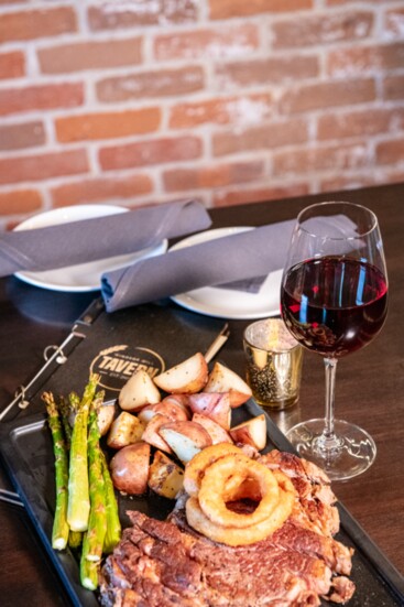 The Colorado Ribeye at the Tavern is a 22 oz. Colorado Custome Meats Co. steak, with roasted red potatoes, seasonal Vegetables, and crispy onions.