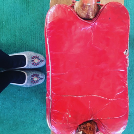 Guests at Dunton Hot Springs stay cozy in these felted house slippers when they stay for lunch. This red leather stool is a perch in the gathering room. 