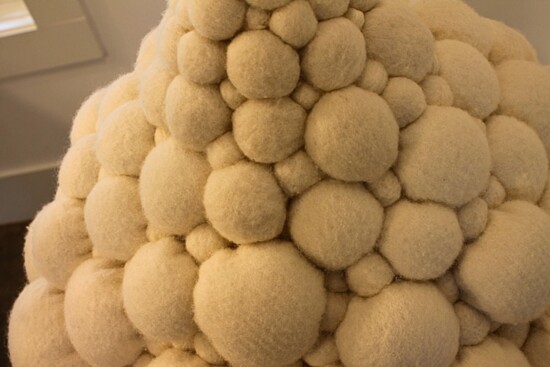 Image Description: White and felt-like fluffy but smooth balls bunched together to form a shape of spheres bunched together