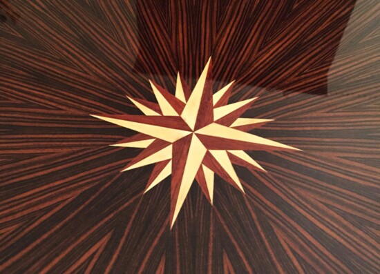 Detail of a 16-point, 32-piece compass rose inlaid within a pie-matched field of Macassar ebony.