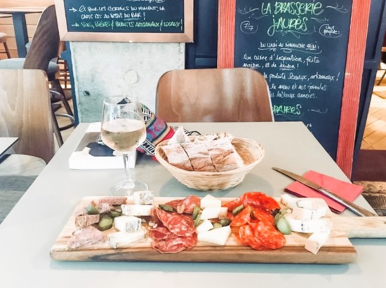 An amazing meat and cheese board with rose wine and bread in Lyon, France. 