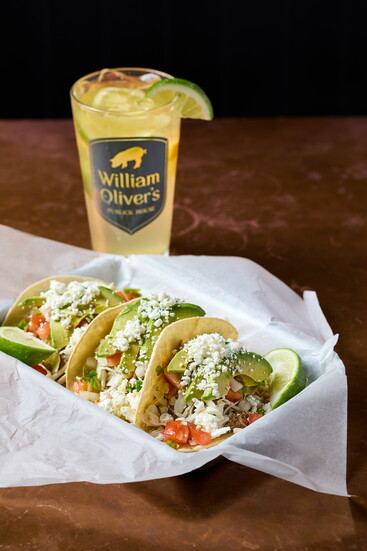 Fresh tacos topped with avocado and feta cheese, paired perfectly with a refreshing beverage. The perfect lunch option!